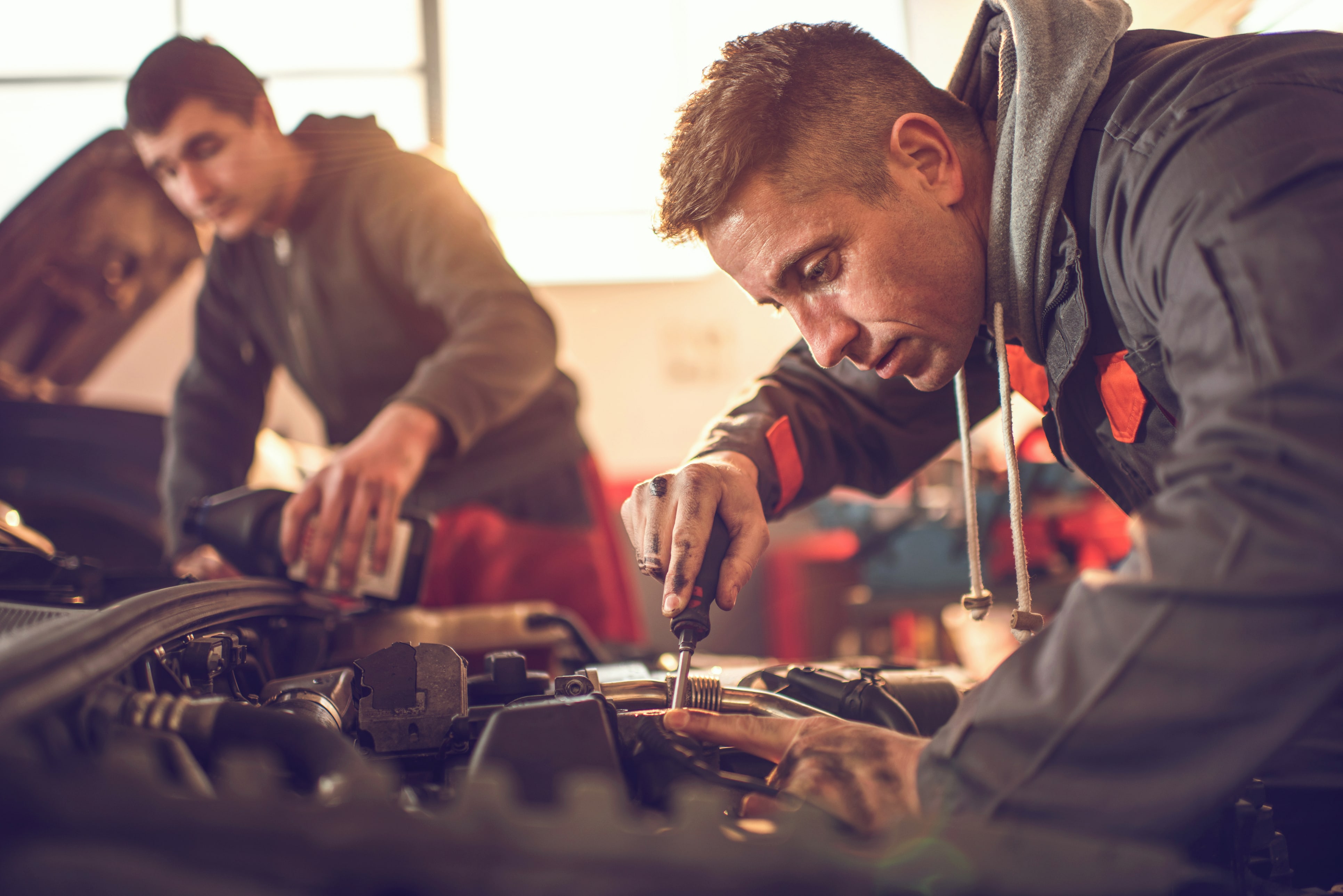 Men work on car engines